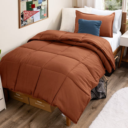 Bed with comforter and pillows in a dorm room