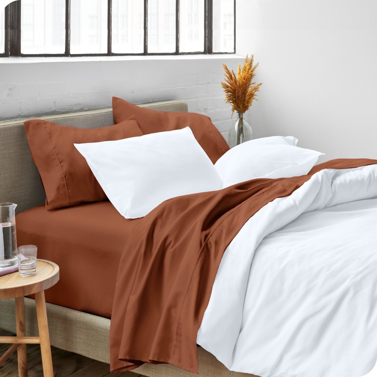 A side view of a bed made with microfiber sheets and a white duvet cover