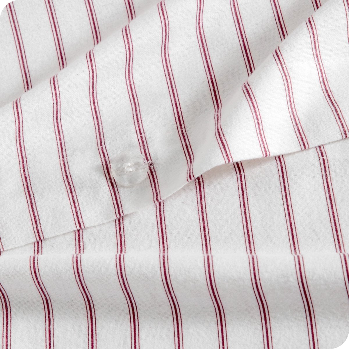 Close-up of a white fabric with thin vertical red pinstripes and a clear plastic button.