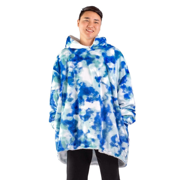 An adult with a hooded wearable blanket on