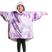 A child is wearing a sherpa wearable blanket and is standing with her arms stretched out.