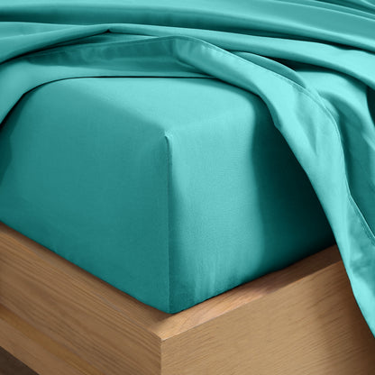 Close up of the corner of a mattress with a fitted sheet and flat sheet on it