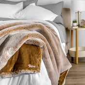 Blanket with 'Bare' branding on a bed in a bedroom setting
