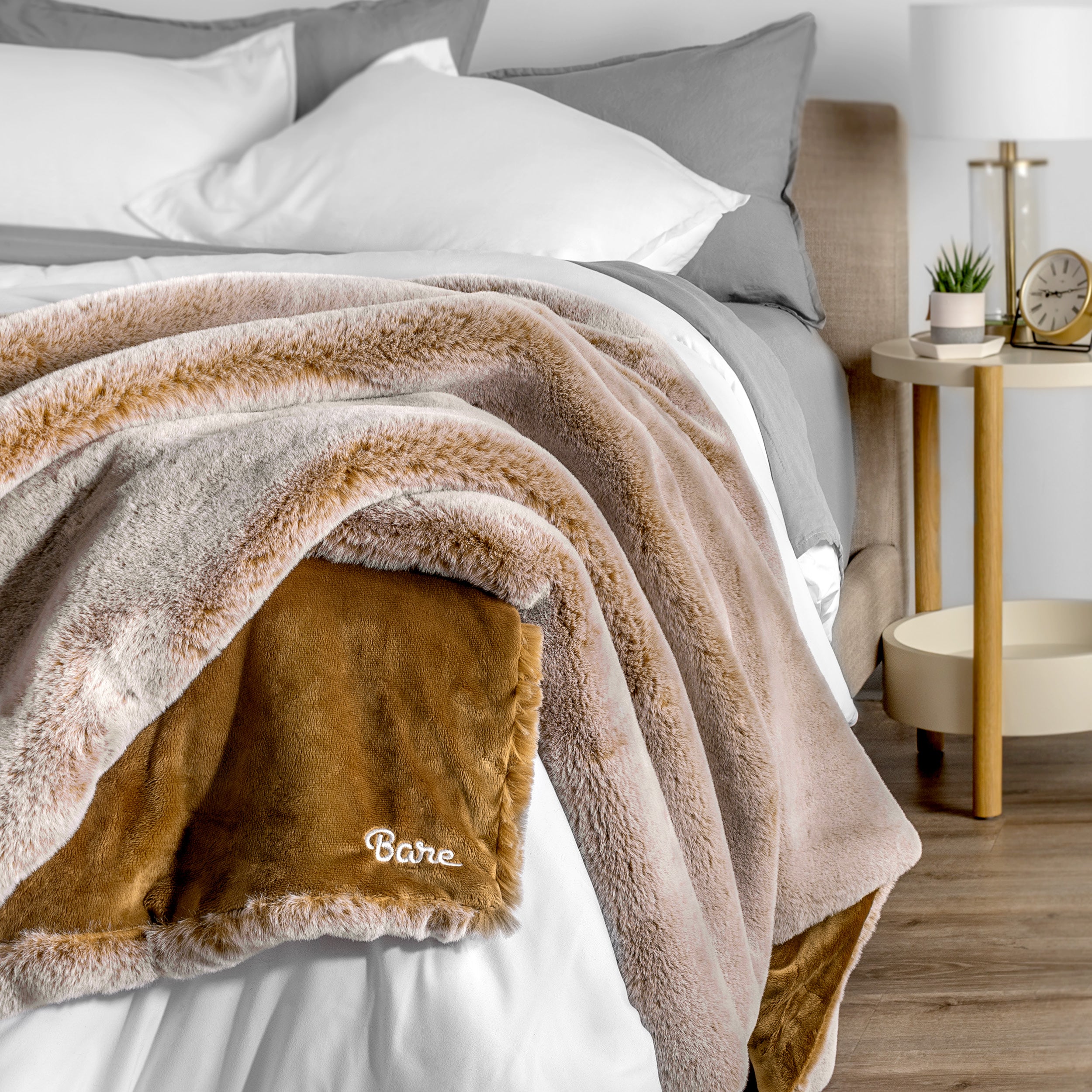 Blanket with 'Bare' branding on a bed in a bedroom setting