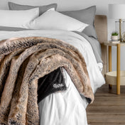 Blanket with 'Bare' branding on a bed in a bedroom setting