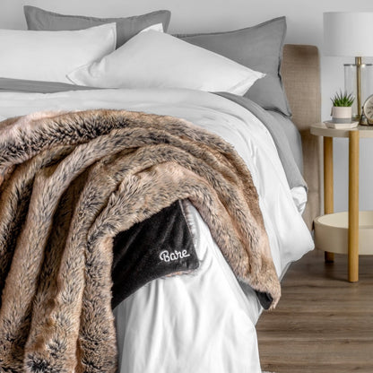Blanket with 'Bare' branding on a bed in a bedroom setting