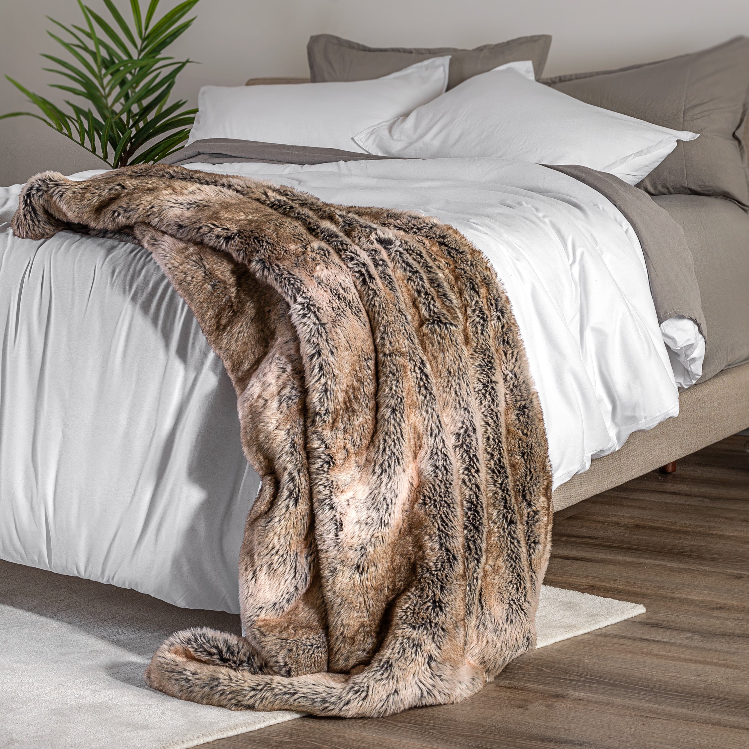 Blanket draped over a bed in a bedroom setting with a nightstand and lamp.