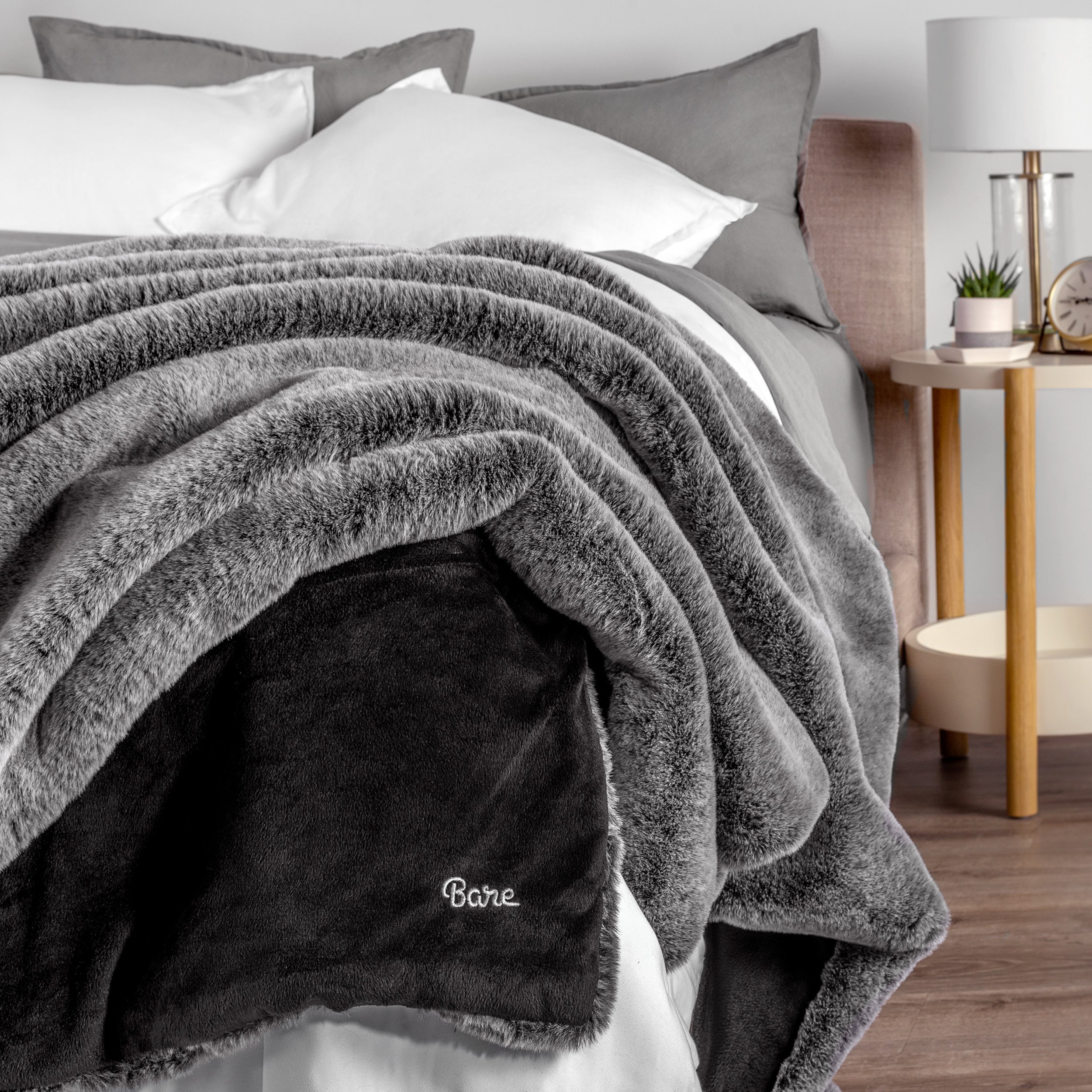Blanket with 'Bare' branding on a bed in a bedroom setting