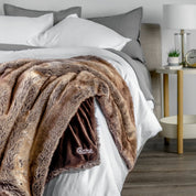 Blanket with 'Bare' branding on a bed in a bedroom setting
