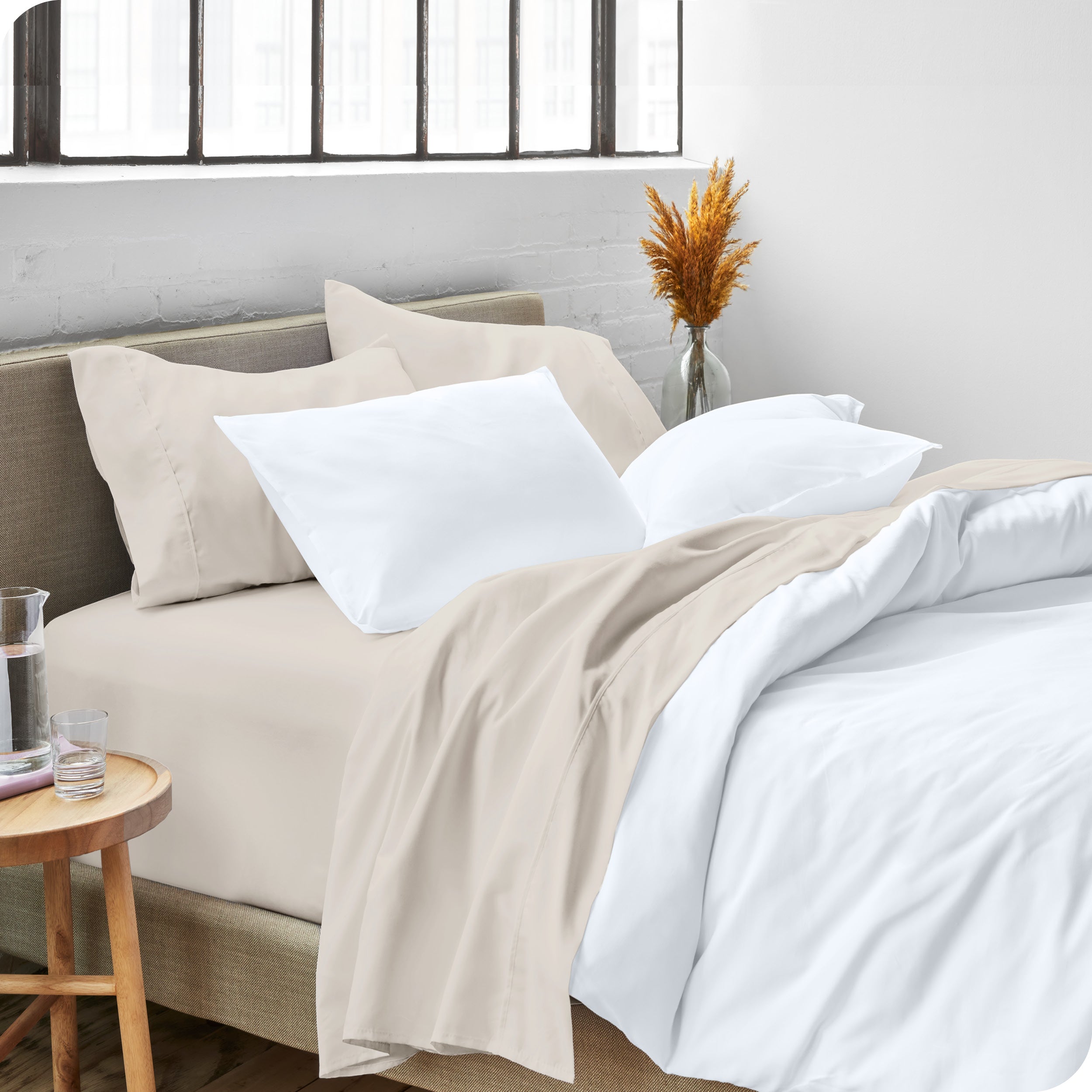 A side view of a bed made with microfiber sheets and a white duvet cover