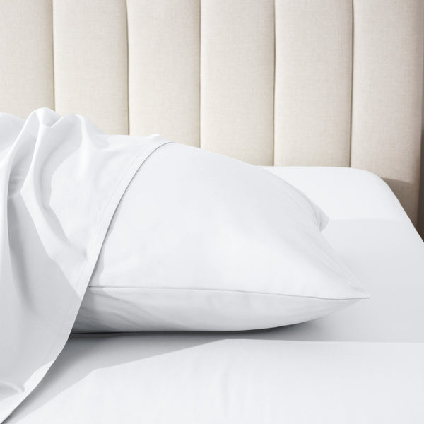 Pillow on a bed with a neutral headboard