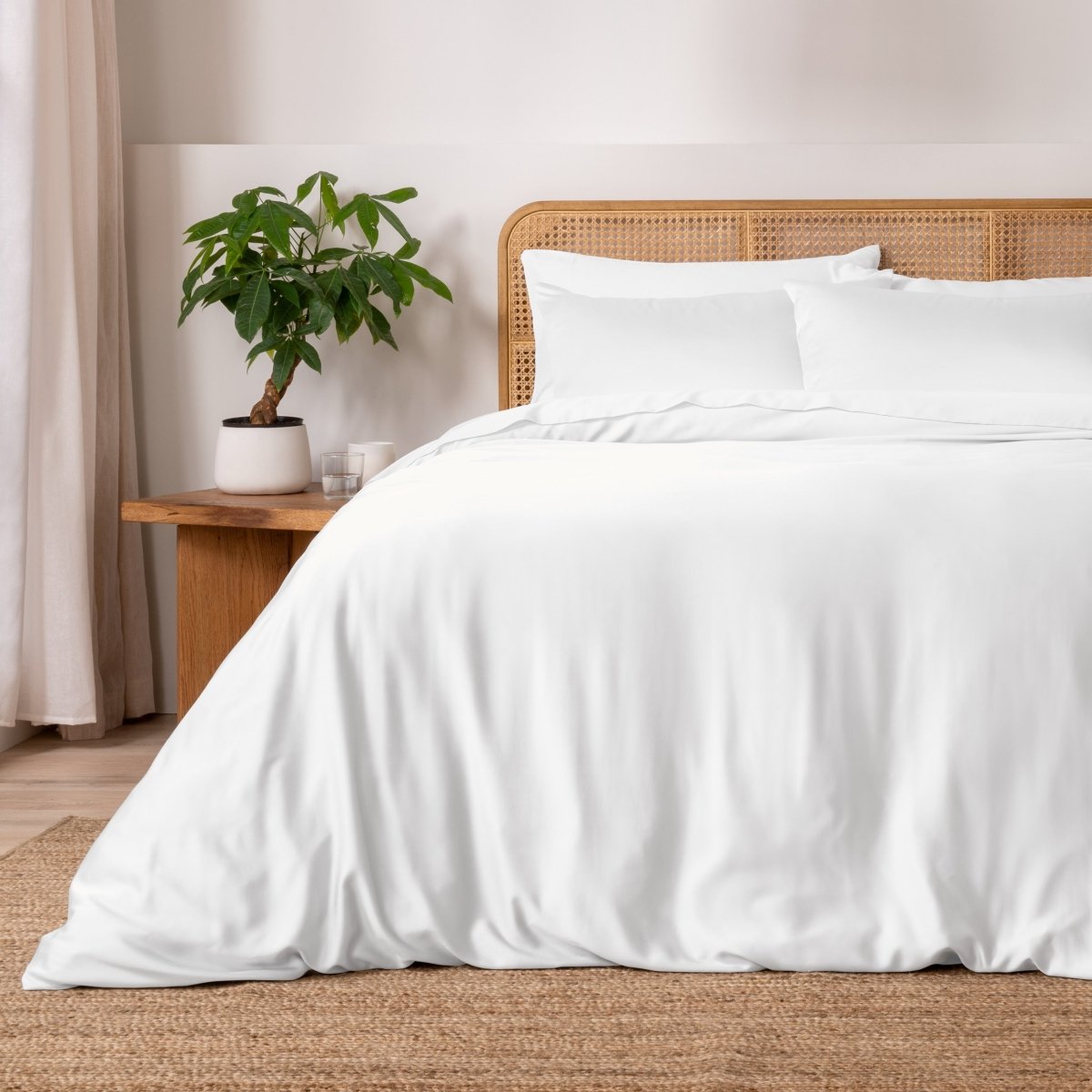Bed with white bedding and a wicker headboard in a bedroom setting.