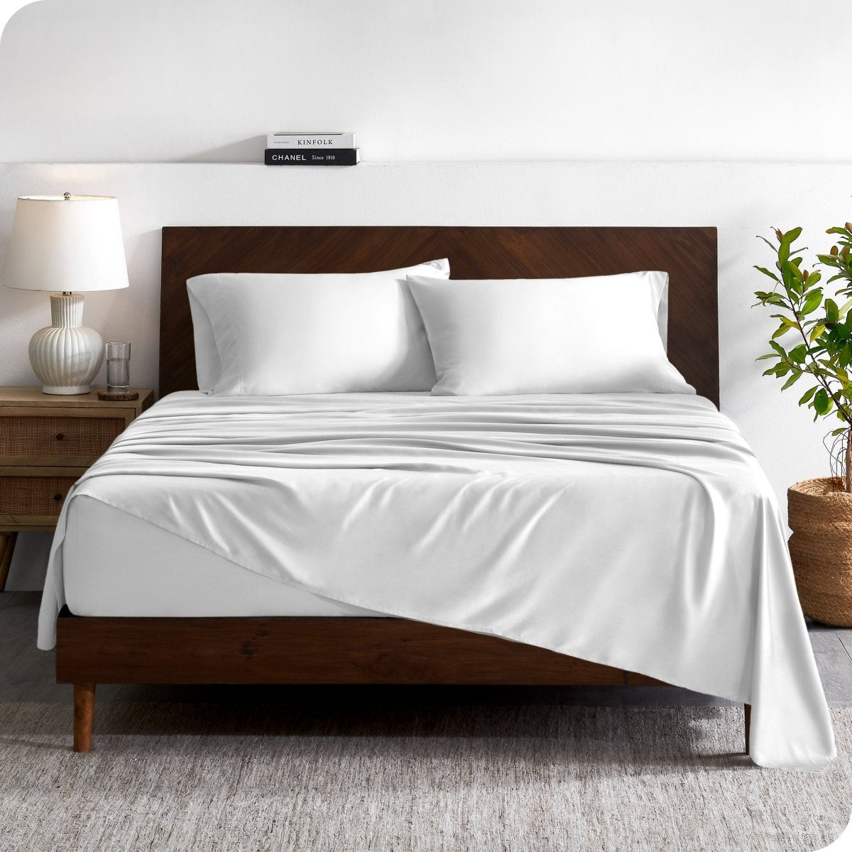 A contemporary bed with a sheet set and a wooden headboard.
