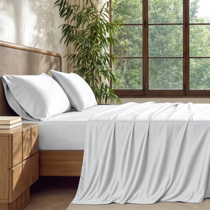 A brightly lite bedroom with bamboo sheets on the bed.
