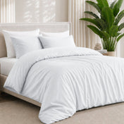 Bamboo bedding set on a bed in a bedroom with a plant in the corner.