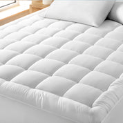 A cotton top mattress pad on a mattress in a modern bedroom.