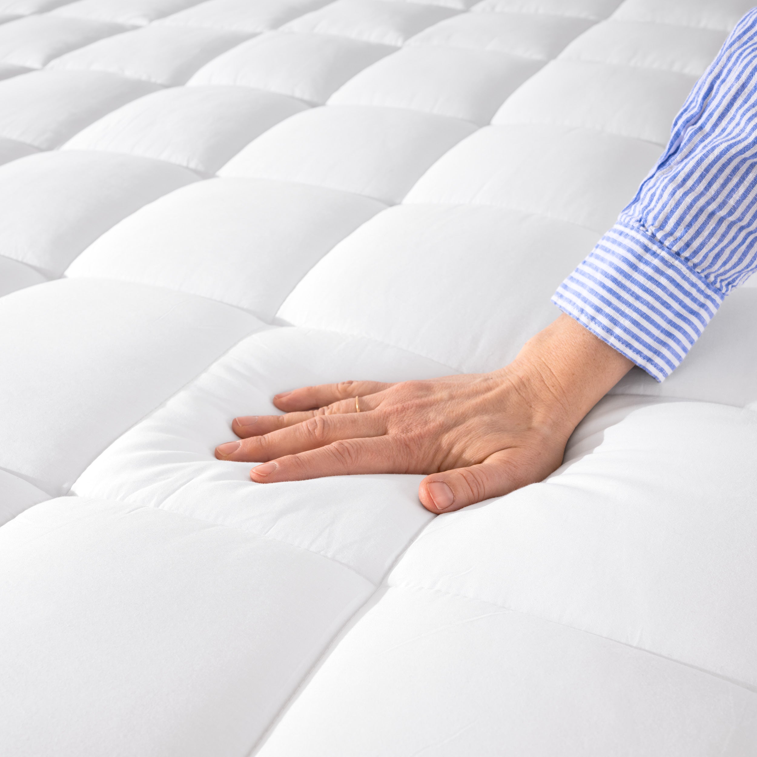 Close up of a cotton mattress pad showing the box-stitching.