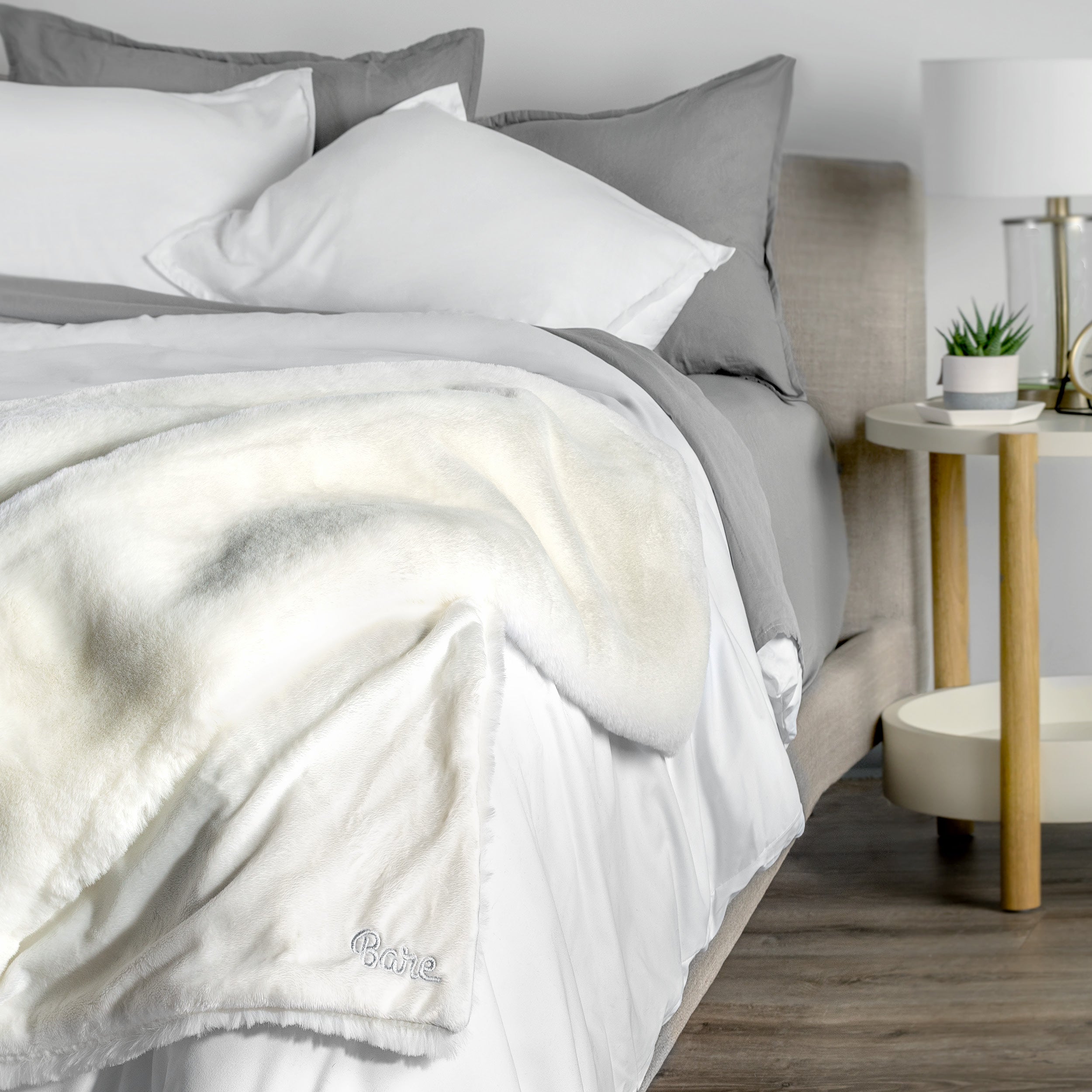 Blanket with 'Bare' branding on a bed in a bedroom setting