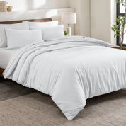 Flannel duvet cover set on a bed in a bedroom with a lamp and plant in the background.