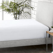 A sideview of a modern bed with a flannel fitted sheet.