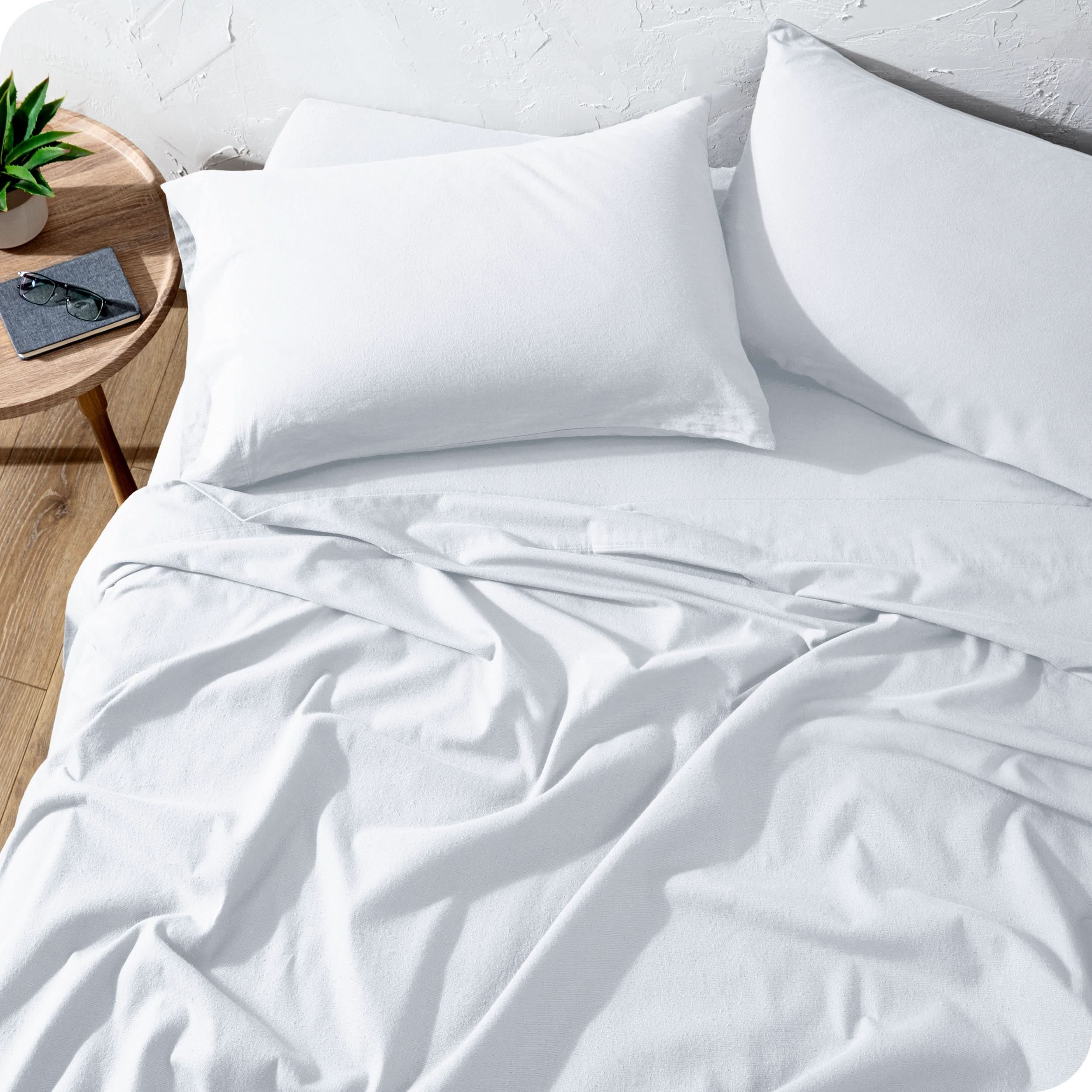 A high front view of a modern bed with a flannel sheet set on it