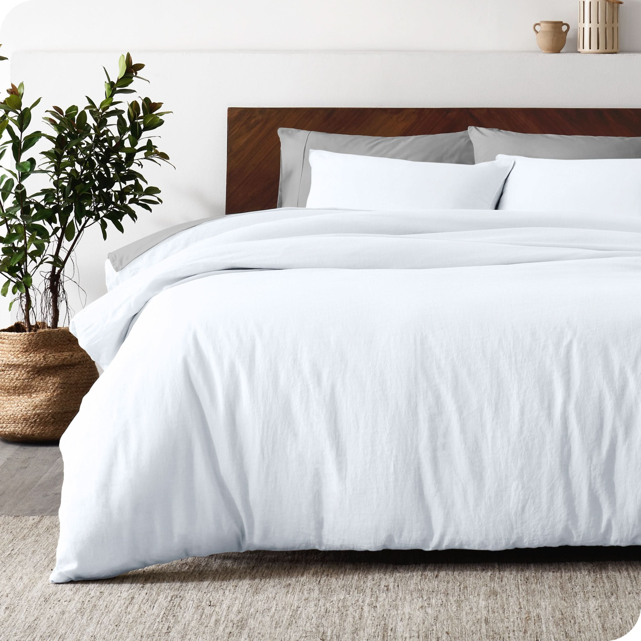 Relaxing room scene showing soft white linen duvet cover set laid out over the bed