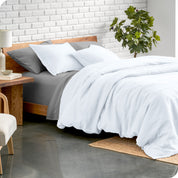 Relaxing room scene showing soft white linen duvet cover set laid out over the bed