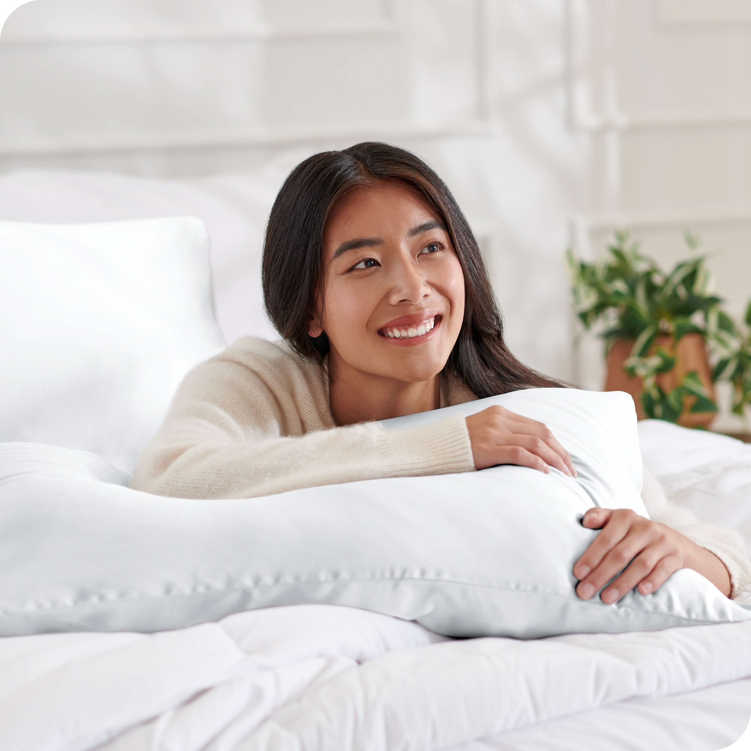 A woman lying on a bed with silk pillowcases