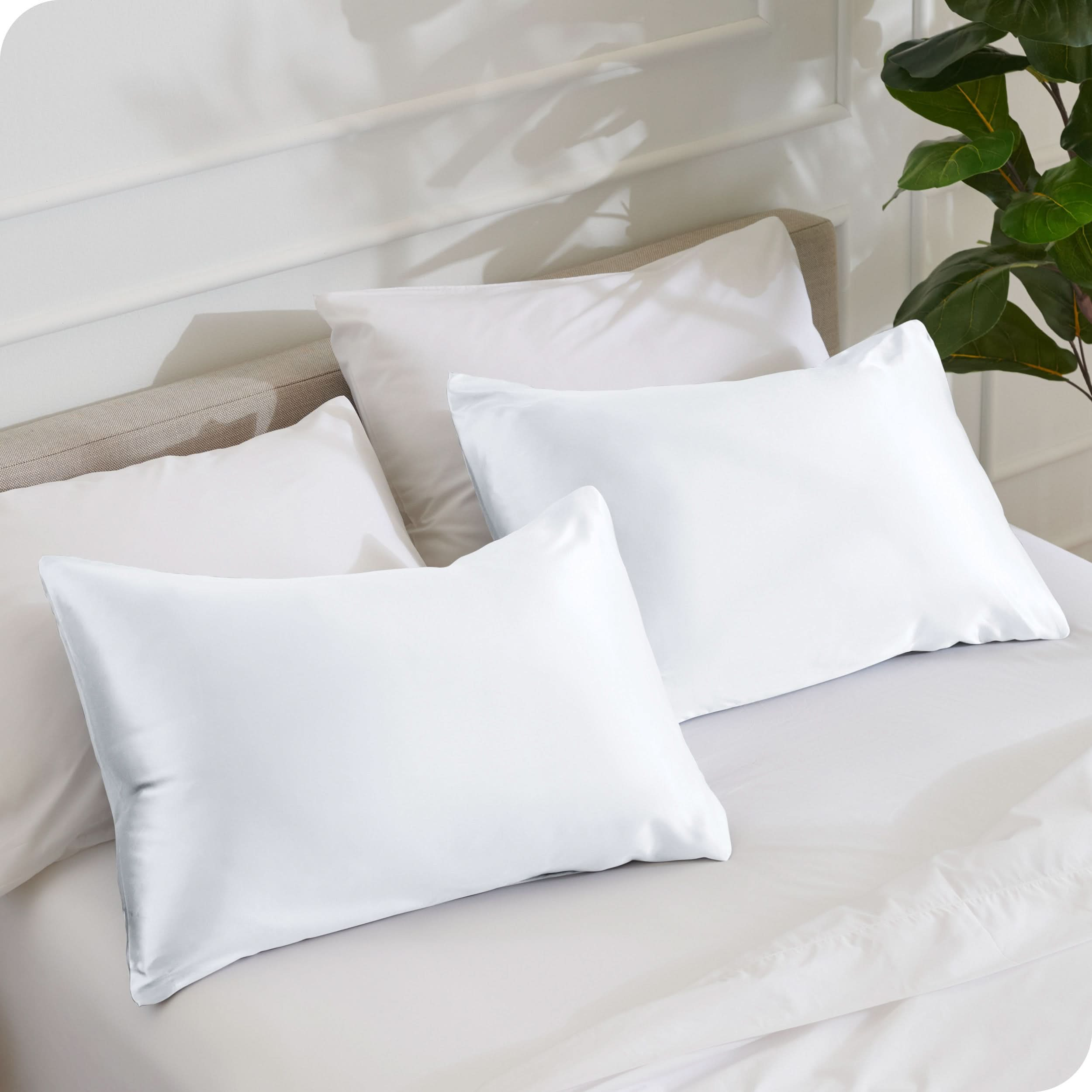 2 silk pillowcases on a bed with white linens