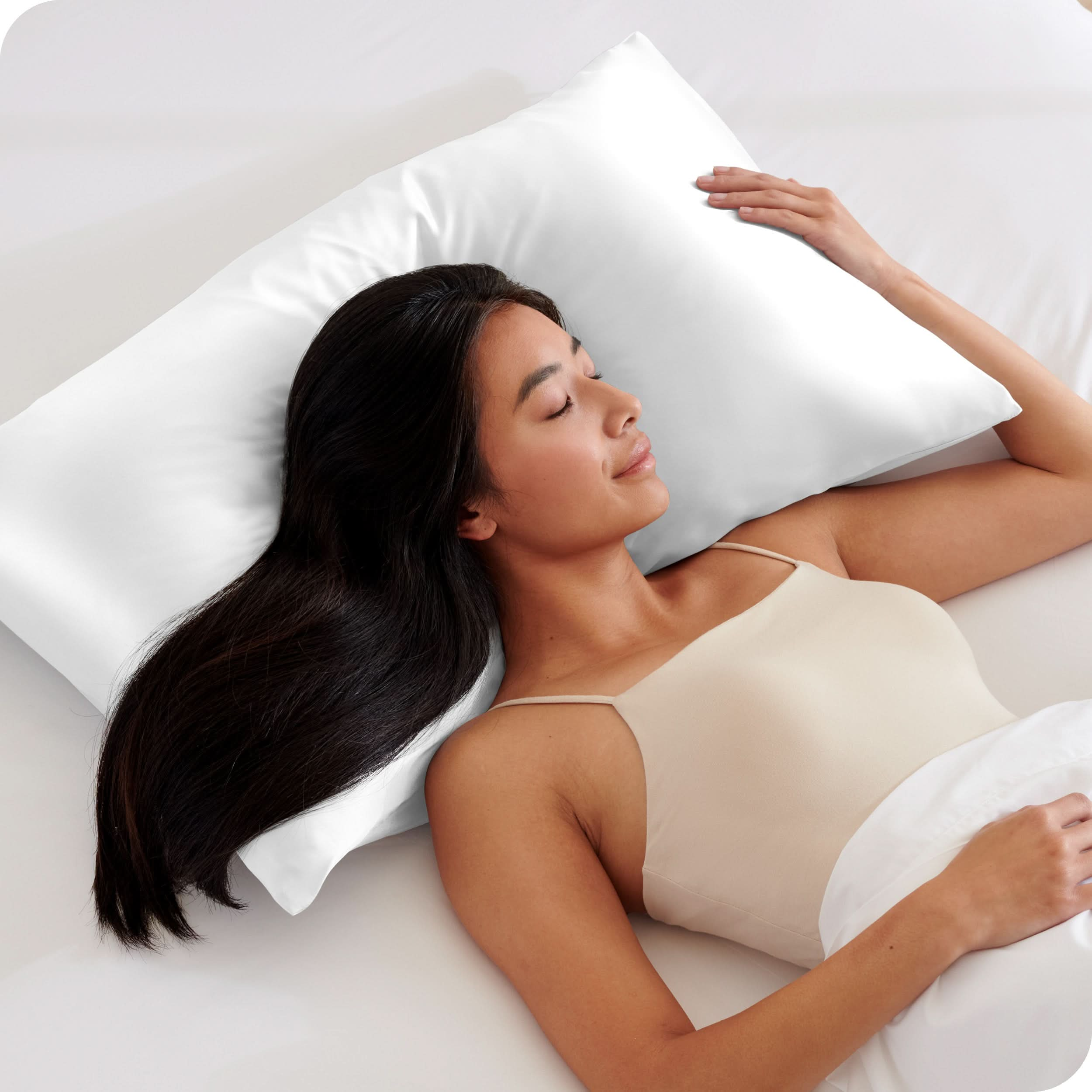 A woman is sleeping with her head on a silk pillowcase