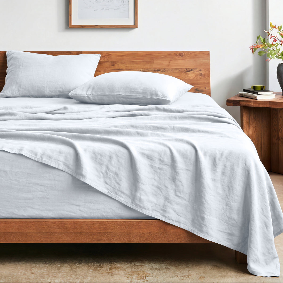 Bed with washed sheets and wooden headboard in a bedroom setting