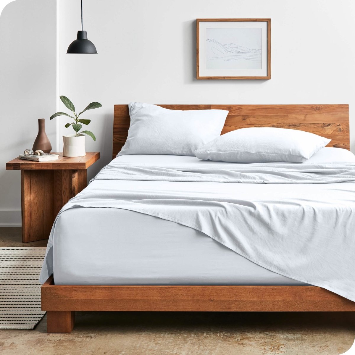 Modern bedroom with washed sheets draped over the end and the side of the bed