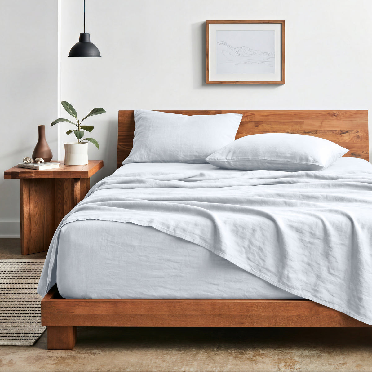 Bedroom with sheet set on a wooden bed frame and side table