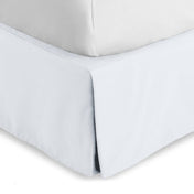 Bed skirt on a bed with white bedding
