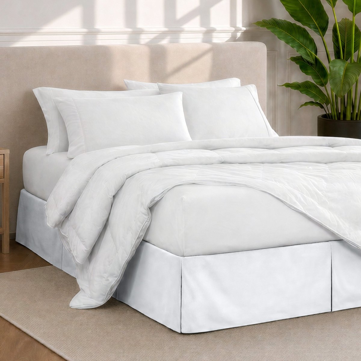 A modern bedroom with a bed skirt, comforter and sheets on the bed