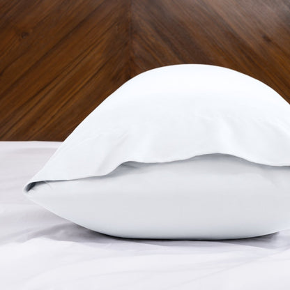 Body pillowcase with an envelope closure on a bed with a wooden headboard