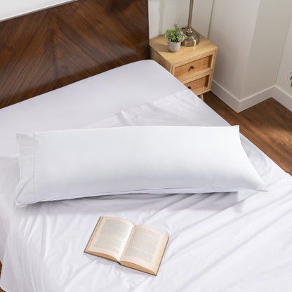 Pillowcase on a body pillow with a wooden headboard and plant in the background