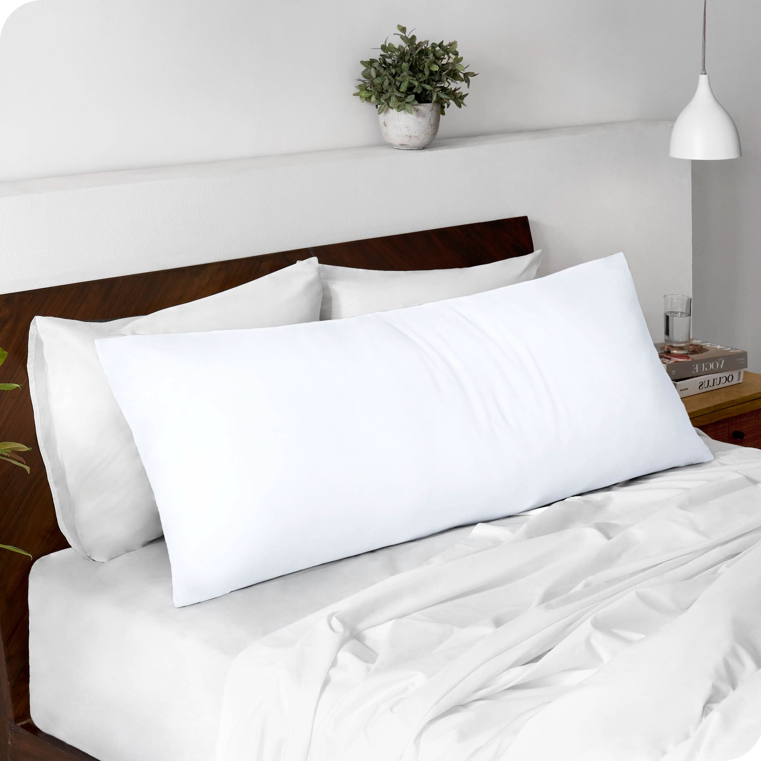 A body pillowcase on a pillow set against a headboard