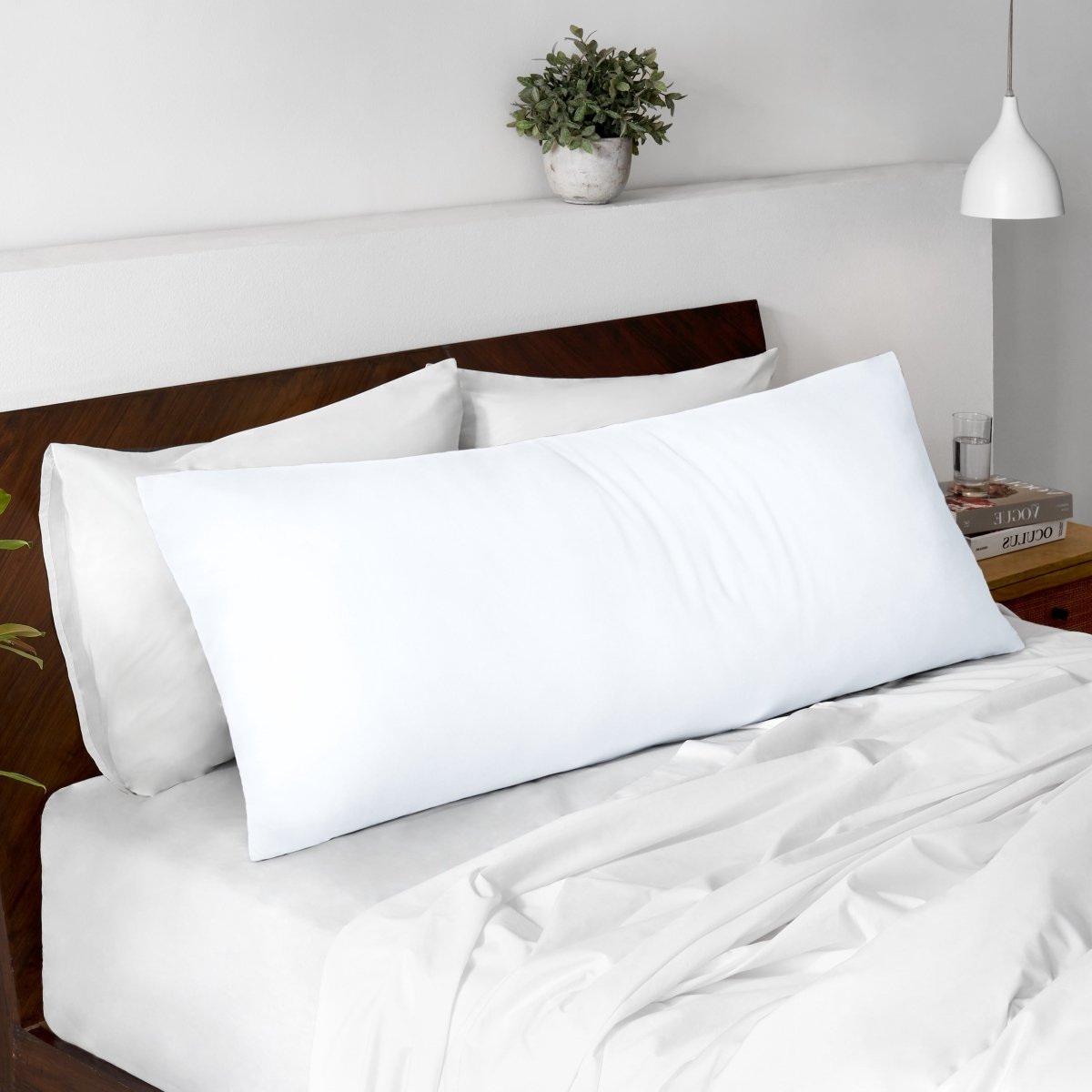 Body pillow on a bed with a wooden headboard and minimal decor.