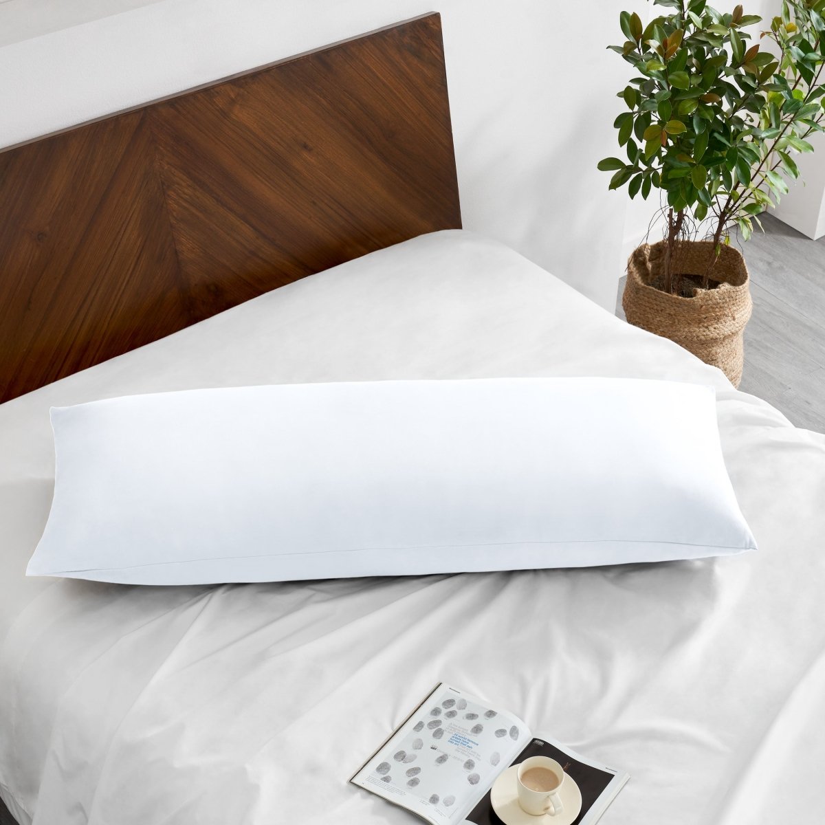 Pillowcase on a body pillow with a wooden headboard and plant in the background
