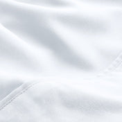 A close-up of microfiber fabric with soft folds and a visible stitched seam.