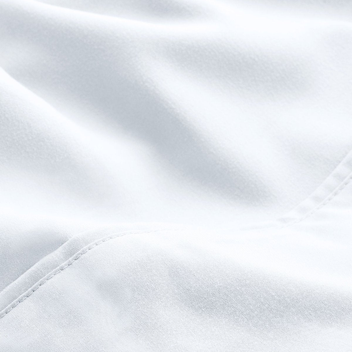 A close-up of microfiber fabric with soft folds and a visible stitched seam.
