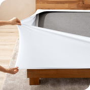 A person stretching a box spring cover