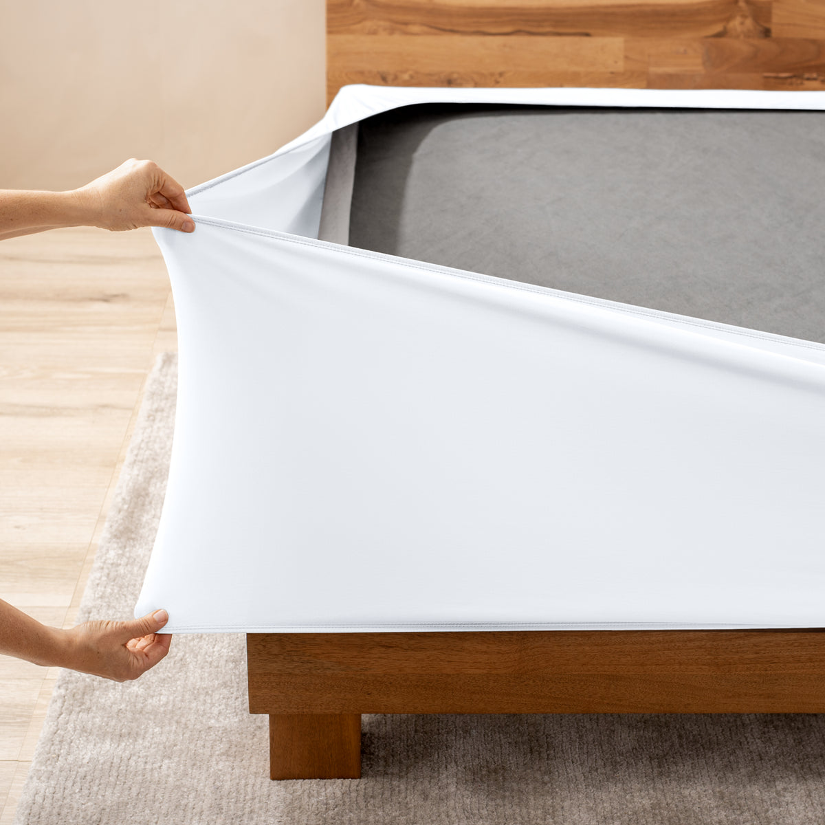 A person stretching a box spring cover