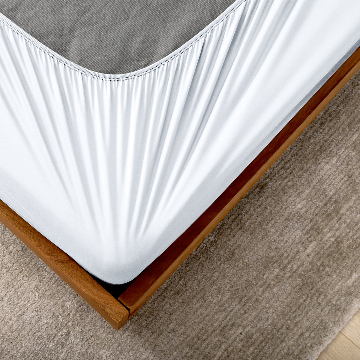 The corner of a box spring with a cover on it