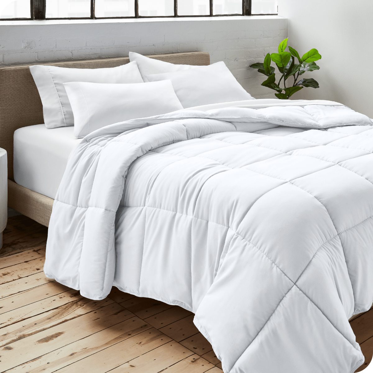 A bedroom with a duvet insert, pillowcases and shams on the bed