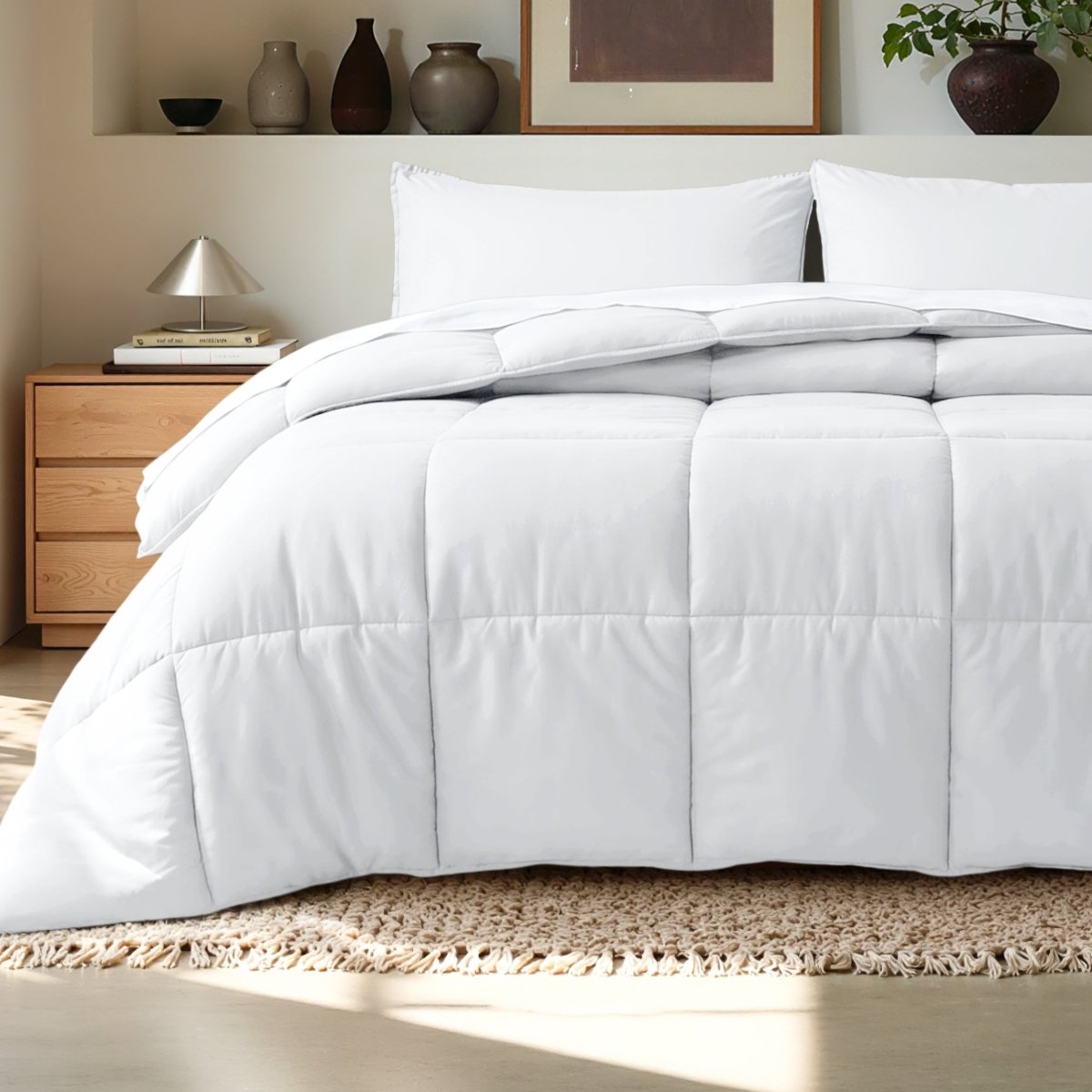 Comforter on a bed in a bedroom setting with a wooden nightstand and decorative items.