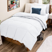 Bed with comforter and pillows in a dorm room