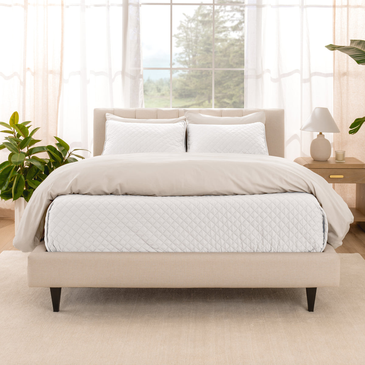 A bright bedroom with a coverlet set on the bed