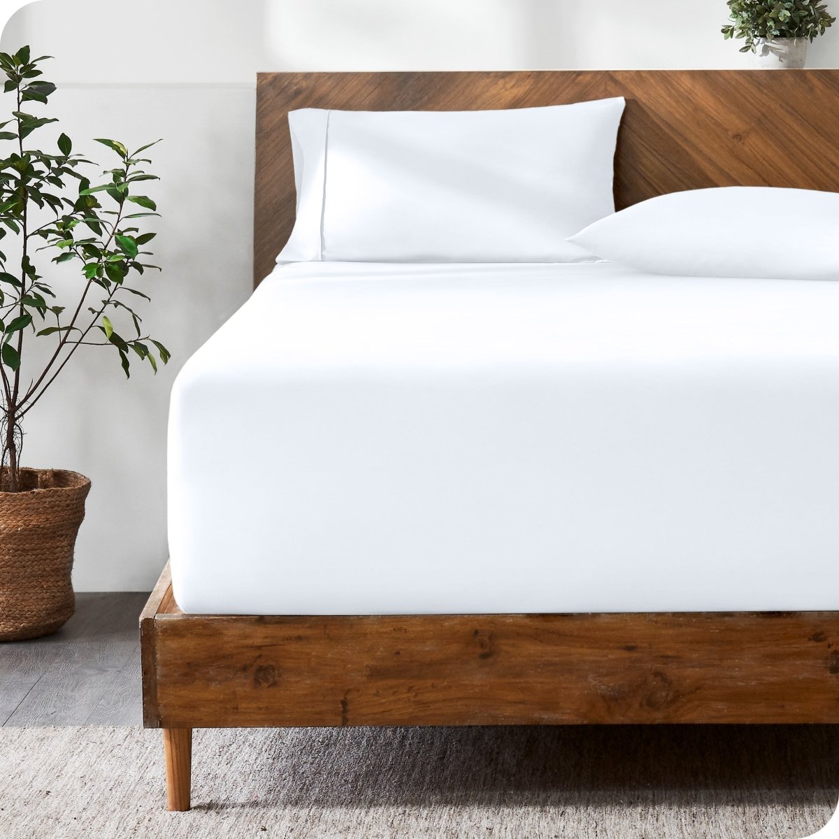 Wooden bed with ultra soft bedding in a minimalistic room.